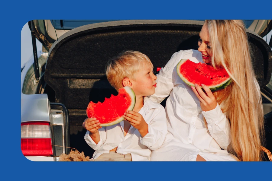 A Child With Her Mother Eat Watermelon