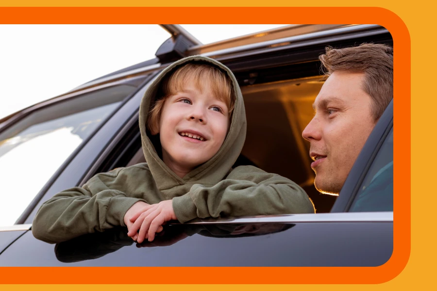 A Little Boy Inside A Car With His Father